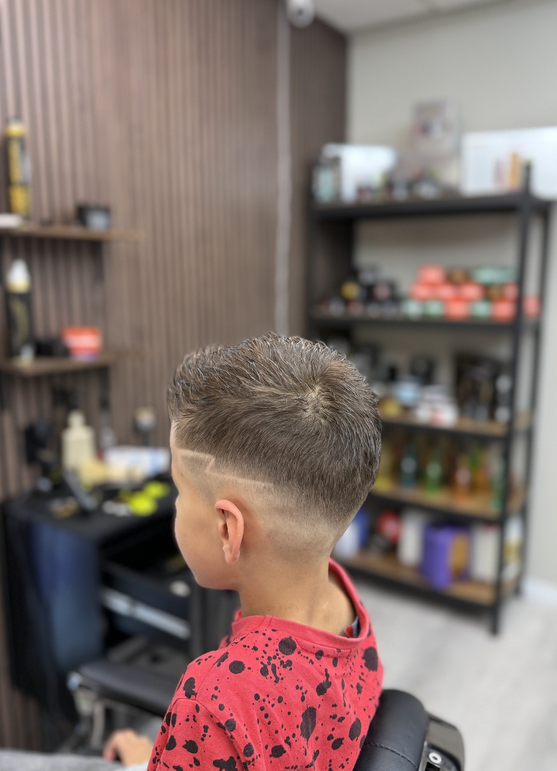 Jongen met een skin fade en een geschoren scheiding