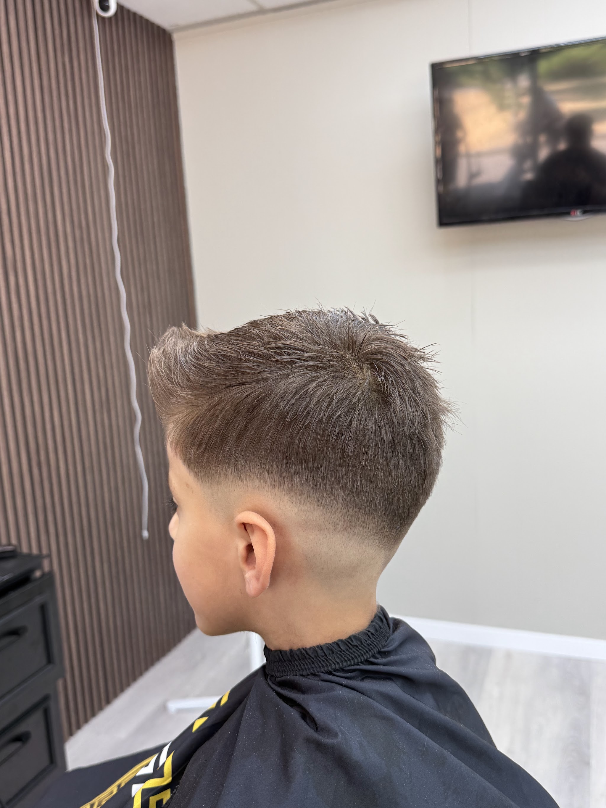 Jongen met een taper fade, van opzij